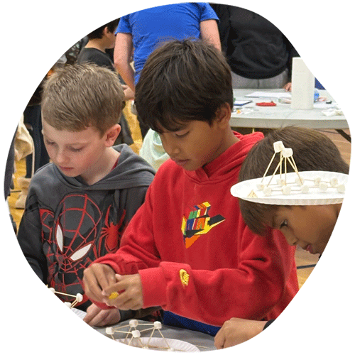Three boys building marshmallow shapes