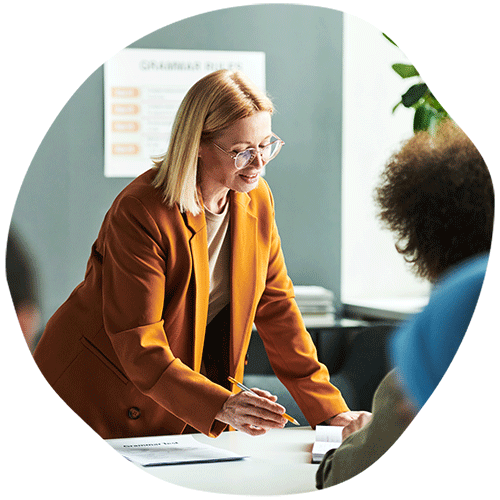 Two women standing over office desk
