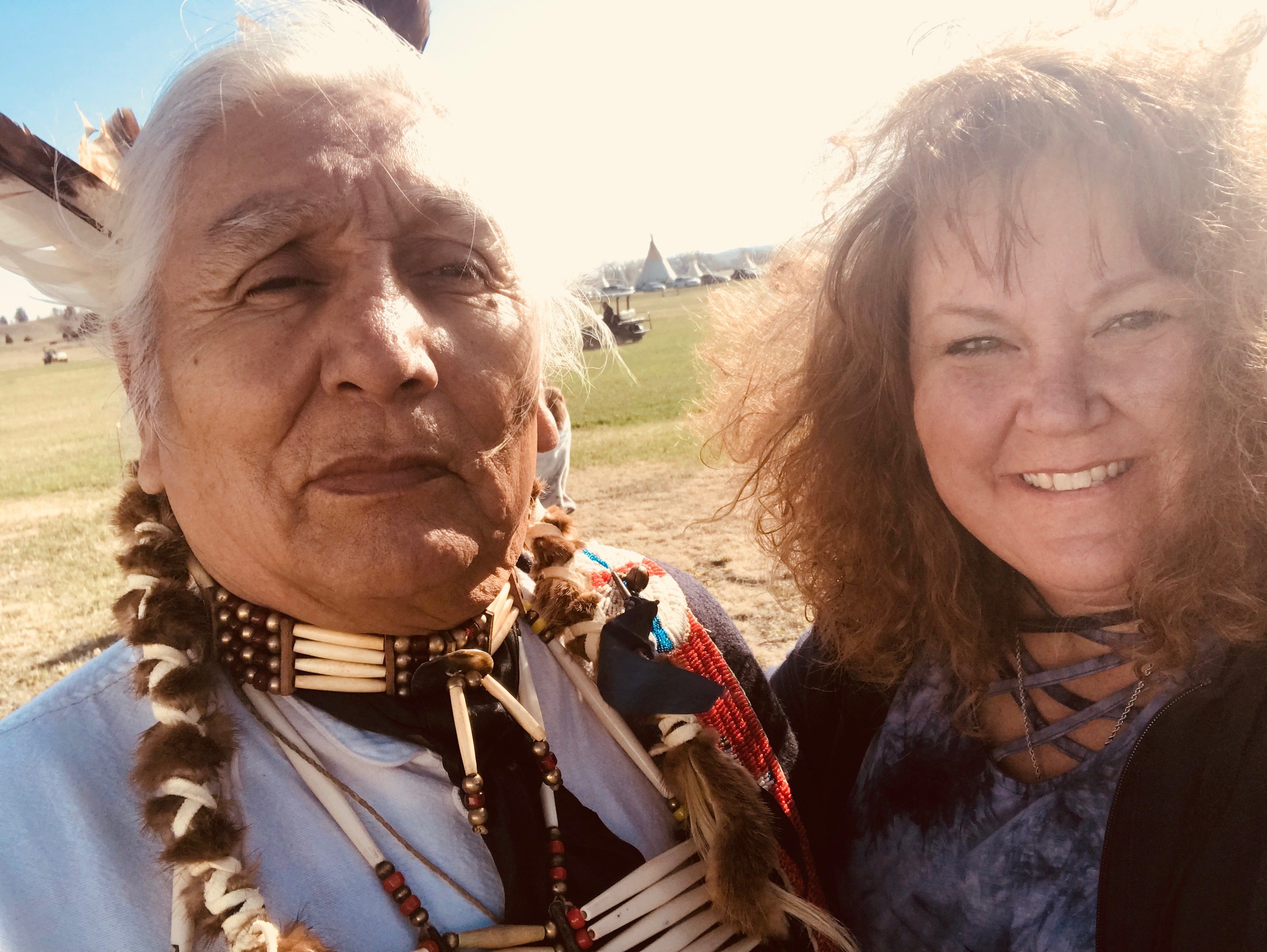 Adults posing outdoors at indigenous event